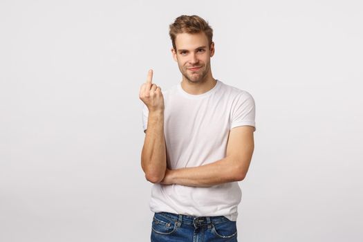 You know what, fuck you. Pissed handsome blond aggressive and rude guy with bristle, showing middle finger, smirk and look camera, telling opponent get lost, having argument, showing bad temper.