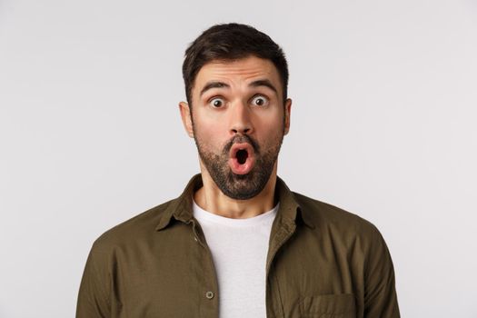 Amazement, emotions and people concept. Close-up astonished, fascinated man in awe, with beard, folding lips gasping speechless and amazed, see thing he wanted with large discount, white background.