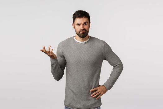 I dont know. Perplexed, indecisive clueless handsome bearded boyfriend in grey sweater, cant figure out what best buy, where shop, raise one hand and shrugging, smirk puzzled, white background.