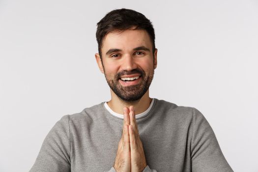 Grateful pleased good-looking bearded man express gratitude and pleasure meet someone, bow politely with hands press together, make pray gesture thanking for help, smiling delighted, white background.