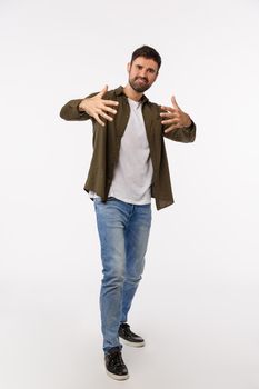 Yo man. Full-length vertical studio shot cool and stylish handsome confident and sassy young bearded man, gesturing with hands as dancing free-style, rap or hip-hop, white background.