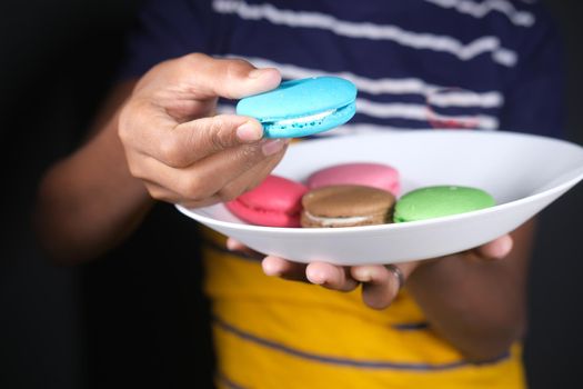 Close up of hand pick macaroon .