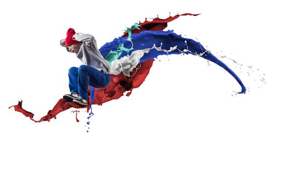 Young male dancer in jump on white background with colorful paint plashes