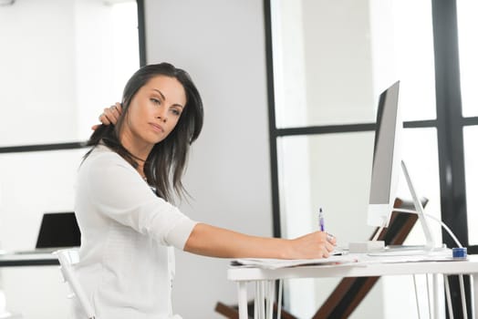 Attractive brunette woman at office desk work on computer