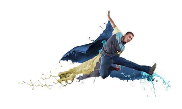 Young male dancer in jump on white background with colorful paint plashes