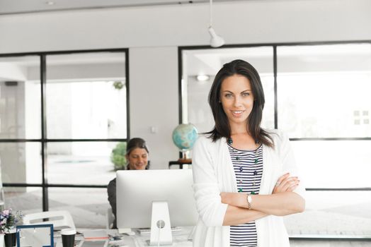 Thoughtful attractive woman standing with arms crossed on chest