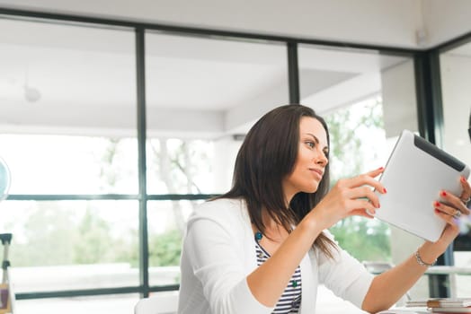 Young attractive brunette working with tablet pc