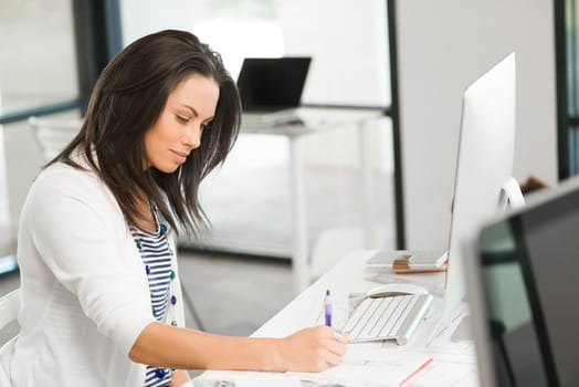 Attractive brunette woman at office desk work on computer