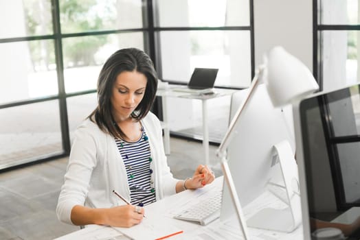 Attractive brunette woman at office desk work on computer
