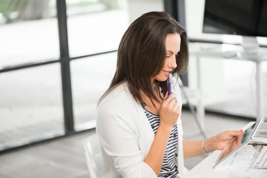 Young attractive brunette working with tablet pc