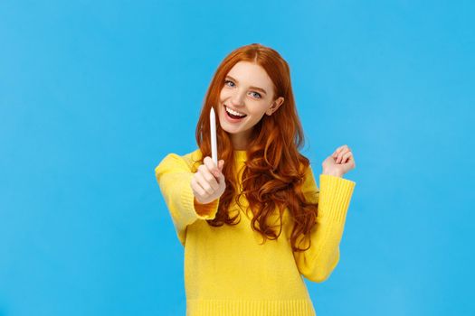 Be author of your own future. Cheerful and creative excited redhead woman giving you pen and smiling, want autograph, want friend draw something, smiling joyfully, standing blue background.