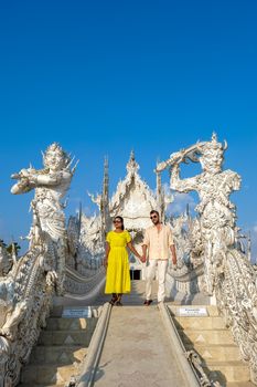 Chiang Rai Thailand, white temple Chiangrai during sunset, Wat Rong Khun, aka The White Temple, in Chiang Rai, Thailand. Panorama white temple Thailand, couple man and woman visit temple