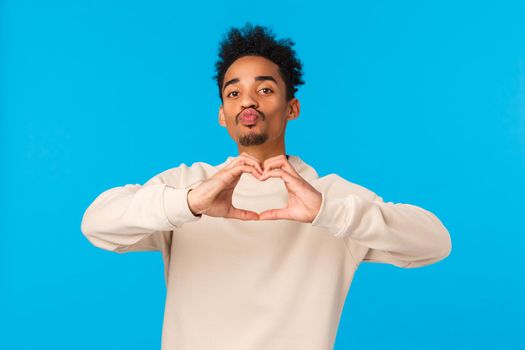 Relationship, romance and feelings concept. Man decided give himself as present for valentines day. Cheeky cute african american boyfriend showing heart sign with love and folding lips to kiss.