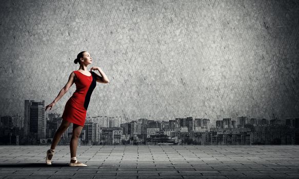Gorgeous young ballet dancer wearing red dress over modern city background