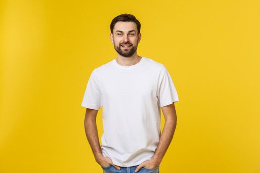 Portrait of a handsome young man smiling against yellow background.