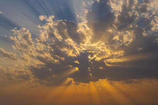 Dramatic sunset and sun rays through the clouds