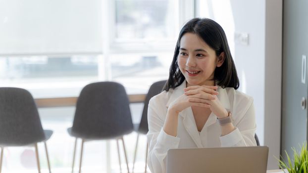 Portrait,  Happy Asian young businesswoman Smiling and listening intently to partner or customer in modern workplace. Banner copy space.