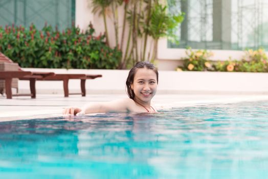 Beautiful asian woman smiling in a swimming pool