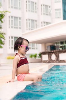 Little girl having fun in the pool. Summer holidays and vacation concept