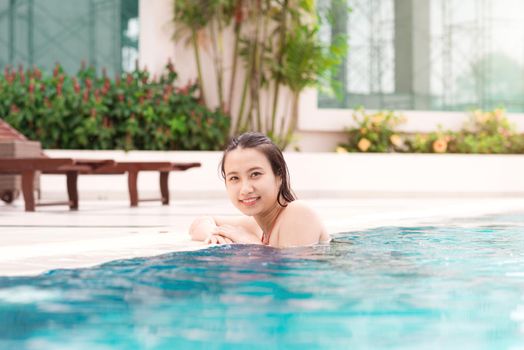 Beautiful asian woman smiling in a swimming pool