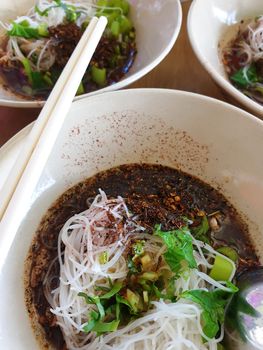 Braised beef clear noodle with meat balls soup stew (Ekaehla meat) with vegetable in bowl for sale at Thai street food market or restaurant in Thailand