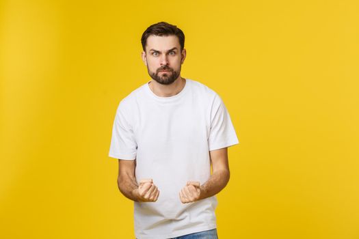 Portrait unhappy handsome man looking at camera on yellow background