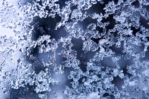 Frozen water drops - natural winter ice pattern on glass, decorative natural frosted ice - melting snowflakes