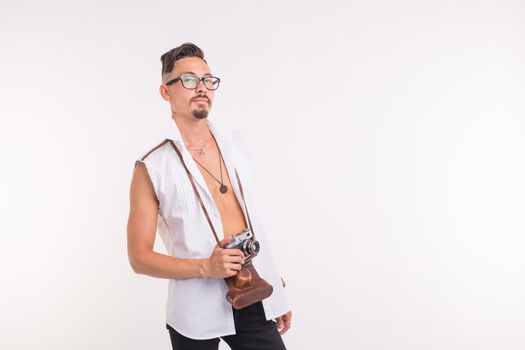 Technologies, photographing and people concept - handsome young man with retro camera over white background.