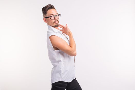 People, clothing and style concept - young handsome man posing in white shirt on white background.