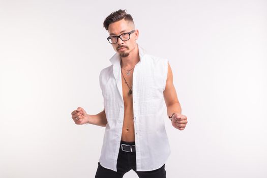 People, clothing and style concept - young handsome man posing in white shirt on white background.