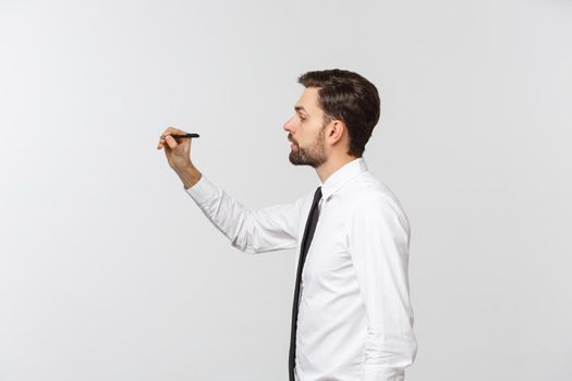 A view of a young businessman holding a pen, ready to write something, isolated on white background.