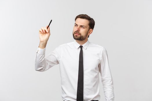 A view of a young businessman holding a pen, ready to write something, isolated on white background.