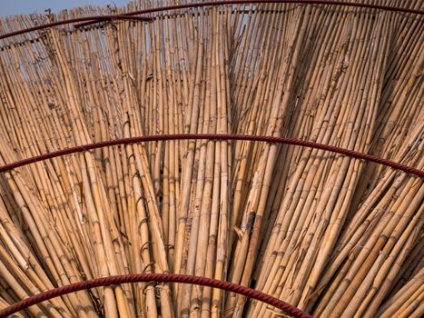 Straw beach umbrella from down side. Made of straw, wood and iron rings.