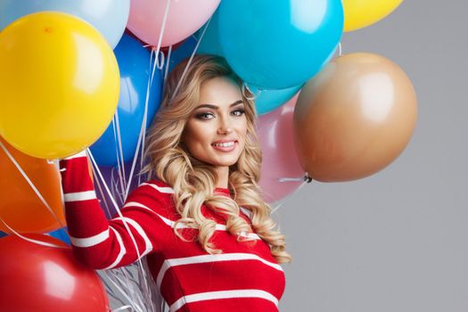 Happy smiling woman with many colorful party balloons
