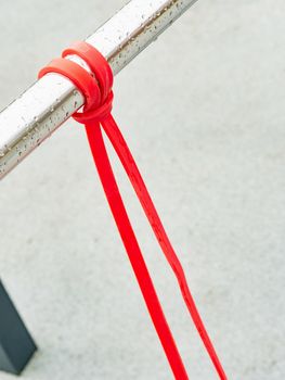 Close-up of a rubber elastic band training knot hanging on a workout crossbar. Wourkout gym after the rain without people