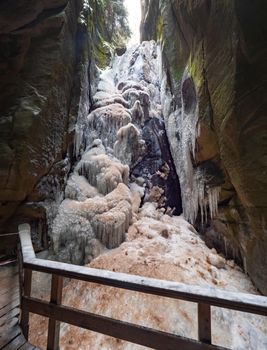 Massive iccicle of frozen Great waterfall in The Rocky town in Adrspach - National Nature Reserve in the Czech Republic, Europe.  