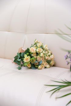 A bouquet of beautiful flowers lies on the sofa. High quality photo