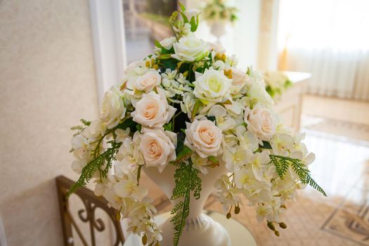 bouquet of roses stands in vase on table. High quality photo