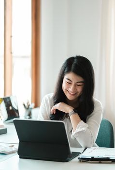 Portrait of Happy Young attractive business woman using digital laptop computer. do math finance on wooden desk, tax, accounting, report statistics and analytical research technology concept.