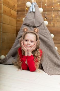 A child in a tent in a red sweater smiles lying in headphones hat New Year's studio wheel park ferris entertainment, carousel outdoor high spin, recreational. Happiness construction fairground, background tourism attraction