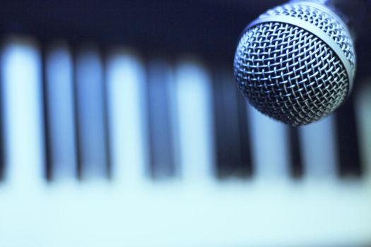 Microphone over piano keys in dim light. No people