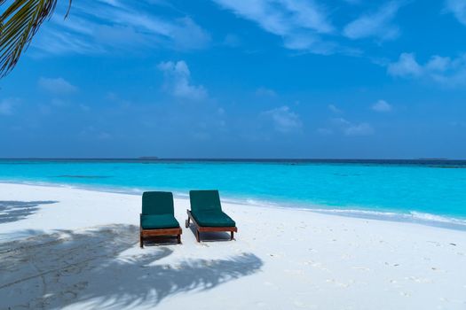 A close-up of sunbeds set on a beautiful tropical beach. Impressive image for every use.