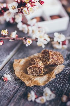 Spring collection of handmade chocolate bonbons candies and cherry flowers decoration on rustic wooden background.