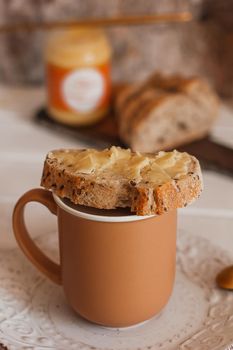 Ghee butter in glass jar and sliced bread on table. Healthy eating, breakfast.