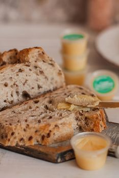 Ghee butter in glass jar and sliced bread on table. Healthy eating, breakfast.