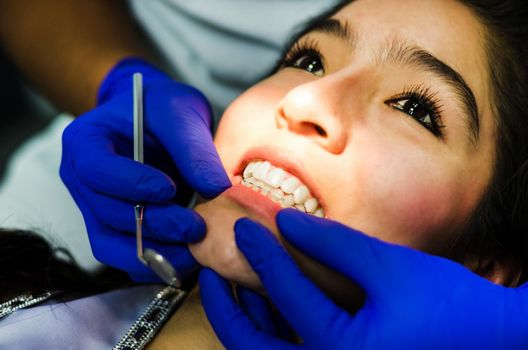 The woman came to see the dentist. She sits in the dental chair. The dentist bent over her. Happy patient and dentist concept.