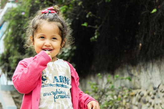 Portrait of cute girl with lollipop smiling in the park