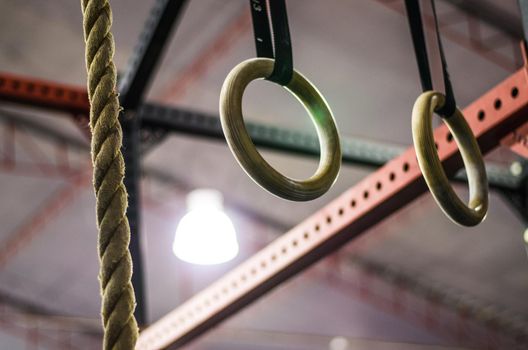 Gymnastic rings in crossfit gym, workout background interior. Motivation.