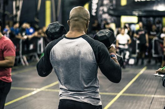 Sport. Muscular african man lifting weights in a gym.