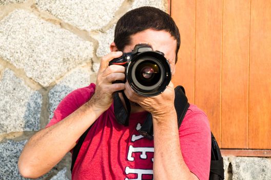 Photographer, taking photos with his professional camera with both hands